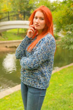 Kazak güzel genç kızıl saçlı kadın sonbaharda yürüyor