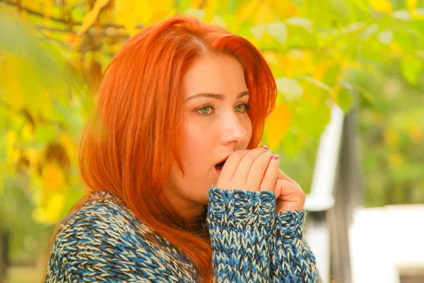 Belle jeune femme rousse en pull avec des feuilles jaunes d'automne arbre automne — Photo