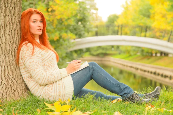 아름다운 젊은 빨간 머리 소녀 독서 책 에서 도시 가을 녹색과 노란색 도시 공원 — 스톡 사진