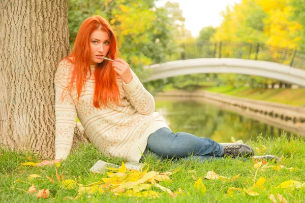 Mulher ruiva bonita jovem em camisola caminha no outono — Fotografia de Stock