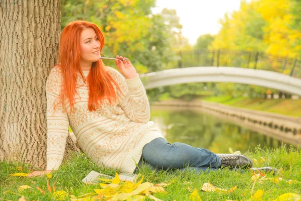 Mulher ruiva bonita jovem em camisola caminha no outono — Fotografia de Stock