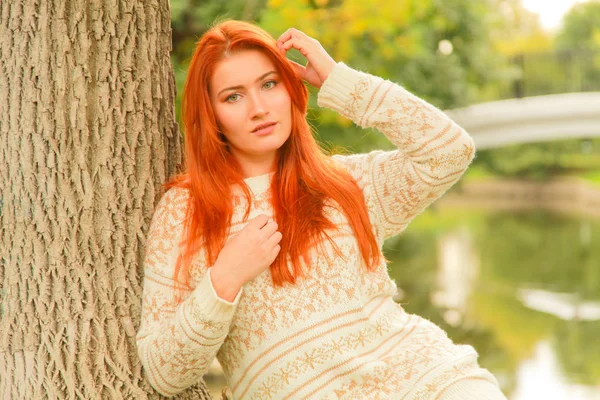 Mulher ruiva bonita jovem em camisola caminha no outono — Fotografia de Stock