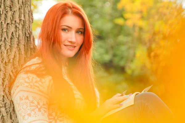 Mooie jonge roodharige vrouw in trui wandelingen in de herfst — Stockfoto