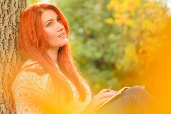 Mooie jonge roodharige vrouw in trui wandelingen in de herfst — Stockfoto