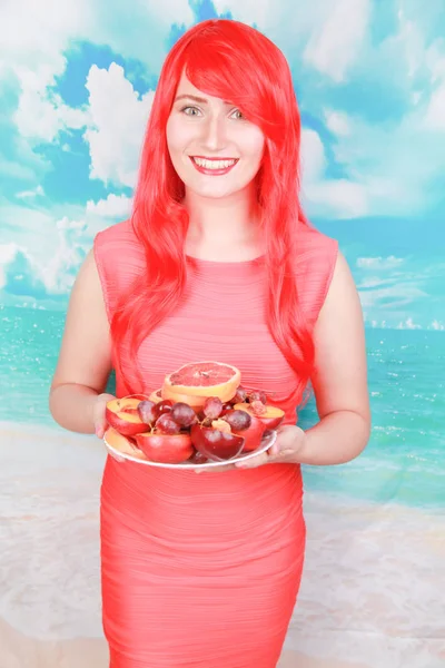 Αρκετά φωτεινή γυναίκα με το πιάτο των φρούτων, η έννοια του καλοκαιριού και υγιεινή διατροφή — Φωτογραφία Αρχείου