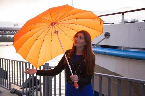 Roodharige vrouwen onder de oranje hartvormige paraplu — Stockfoto