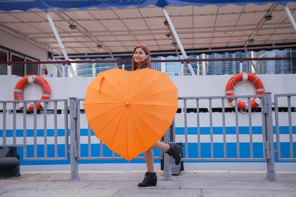 Mujeres pelirrojos bajo el paraguas naranja en forma de corazón — Foto de Stock