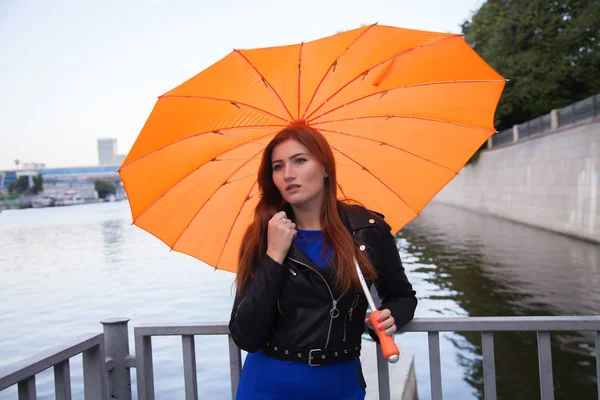 Rudovlasá žena pod deštníkem ve tvaru oranžového srdce — Stock fotografie
