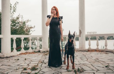 köpeği siyah doberman açık havada birlikte yürüyüş ile güzel kadın sahibi