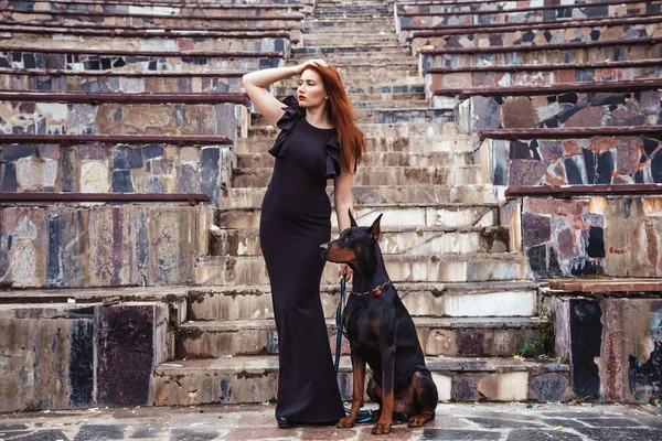 Красивая хозяйка с собакой черный доберман гуляет на свежем воздухе вместе — стоковое фото