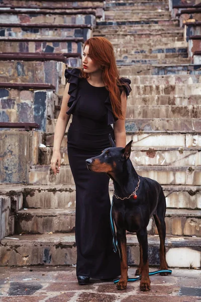 美丽的女人的主人与她的狗黑多伯曼户外一起走 — 图库照片