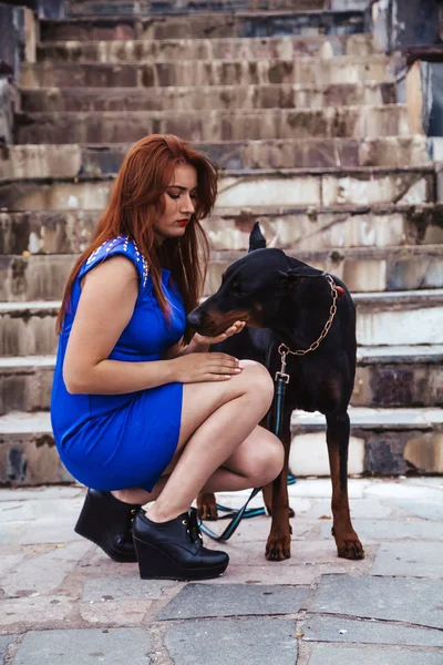 Krásná žena s jejím psem černým dobrmanem venkovní procházky — Stock fotografie