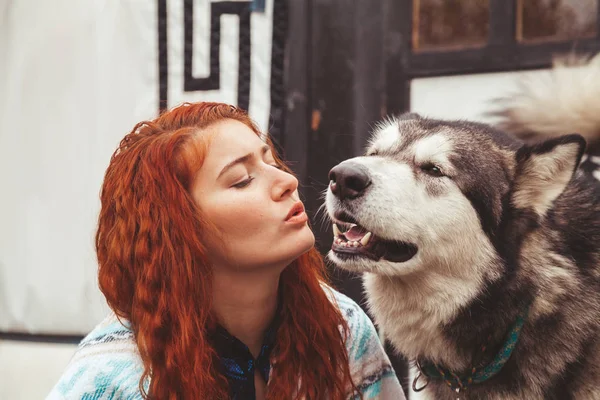 Ragazza con il suo cane Malamute vicino a casa lontano dalla civiltà nel bosco — Foto Stock