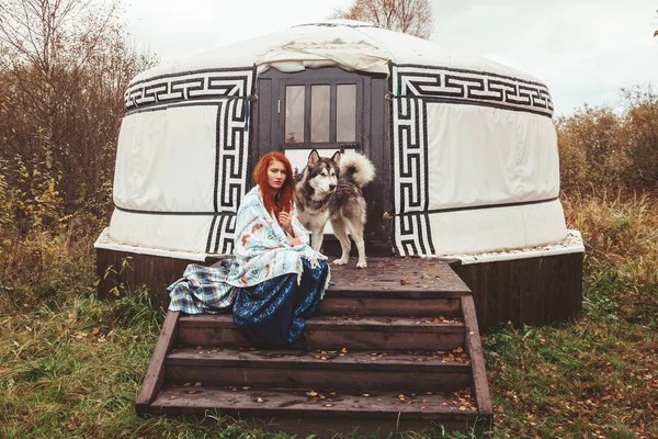 Meisje met haar hond Malamute in de buurt van round Home ver weg van de beschaving in het bos — Stockfoto