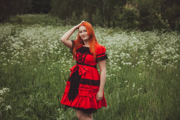 Mulher ruiva bonita em Little Red vestido de conto de fadas no prado grama — Fotografia de Stock