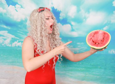 kıvırcık plaj sarışın kızgın yüzü ile karpuz tutan, olumsuz işareti sevmemek gösteren