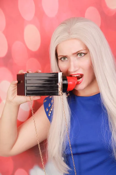 Pretty blonde in blue dress with fashionable big lipstick bag — Stock Photo, Image