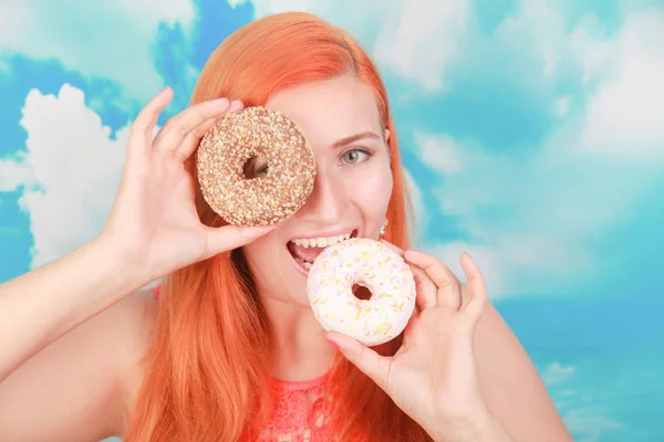 Close up retrato de uma menina bonita satisfeito comer donuts sobre fundo azul — Fotografia de Stock