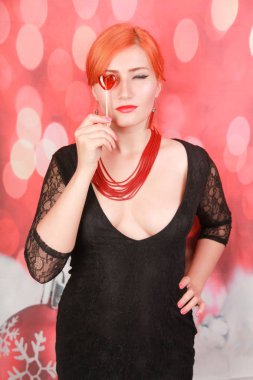 Sürpriz seksi kız lolipop yeme. Kalp şekli kırmızı tatlı ile Güzellik Glamour Model kadın.