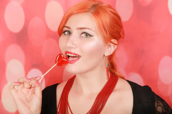 惊讶的性感女孩吃棒棒糖。美女魅力模特 女人 与 心形红色 甜. — 图库照片