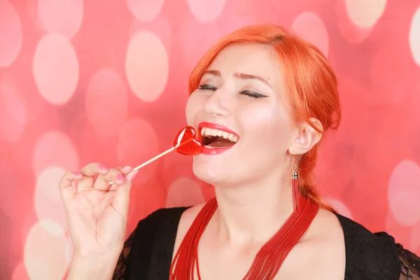Zaskoczony seksowna dziewczyna jedzenia lizak. Piękno Glamour model kobieta z sercem kształt czerwony słodki. — Zdjęcie stockowe