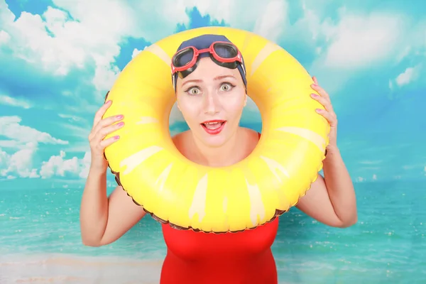 Studio shot of Beauty sexy women wear red vintage swimsuit and carrying life ring on blue sky background — Stock Photo, Image