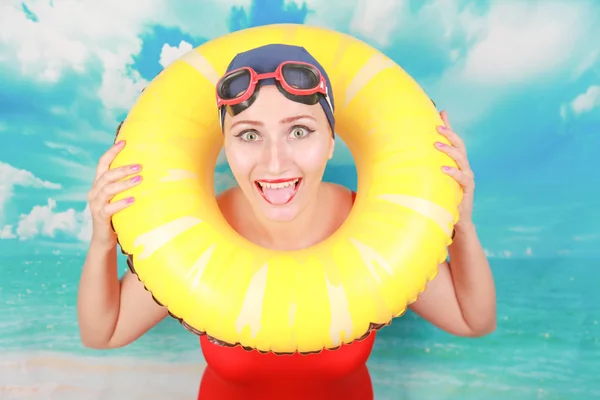 Studio shot of Beauty sexy women wear red vintage swimsuit and carrying life ring on blue sky background — Stock Photo, Image