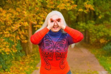 turuncu moda kazak genç güzel artı boyutu beyaz kadın sonbahar parkta yürüyor