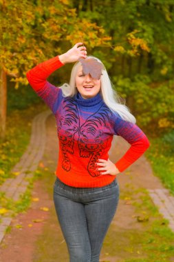 turuncu moda kazak genç güzel artı boyutu beyaz kadın sonbahar parkta yürüyor