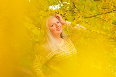 genç güzel artı beyaz kazak beyaz beyaz kadın sonbahar parkta yürüyor