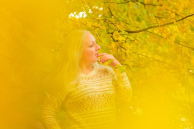 genç güzel artı beyaz kazak beyaz beyaz kadın sonbahar parkta yürüyor