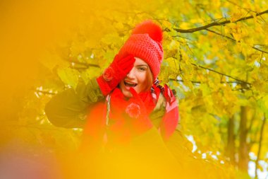 genç güzel artı büyük beyaz kadın pompom ve örme eldiven ile kırmızı şapkalı sonbahar parkta yürüyor
