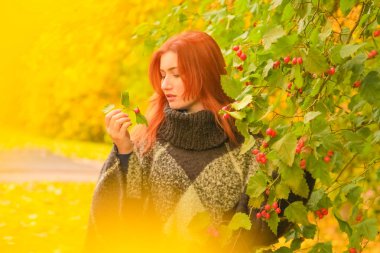 ekose yün poncho genç güzel artı boyutu kafkas kadın sonbahar parkta yürüyor