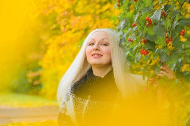 genç güzel artı boyutu kafkas kadın ekose yün poncho sonbahar parkta yürüyor