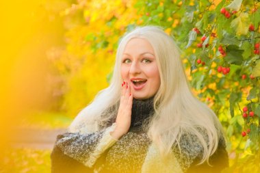 genç güzel artı boyutu kafkas kadın ekose yün poncho sonbahar parkta yürüyor