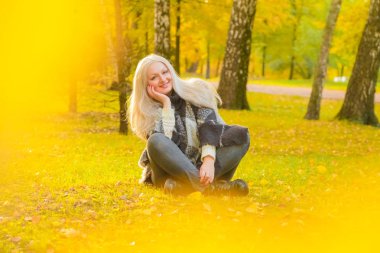 genç güzel artı boyutu kafkas kadın ekose yün poncho sonbahar parkta yürüyor