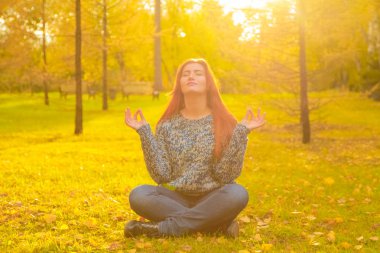 genç güzel artı boyutu kafkas kadın sonbahar parkta meditasyon