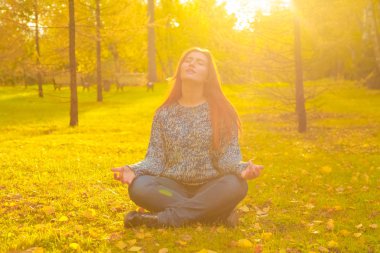 genç güzel artı boyutu kafkas kadın sonbahar parkta meditasyon