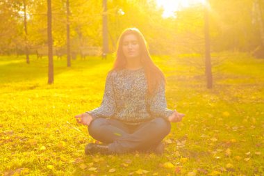 genç güzel artı boyutu kafkas kadın sonbahar parkta meditasyon