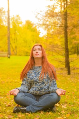 genç güzel artı boyutu kafkas kadın sonbahar parkta meditasyon
