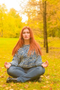 genç güzel artı boyutu kafkas kadın sonbahar parkta meditasyon