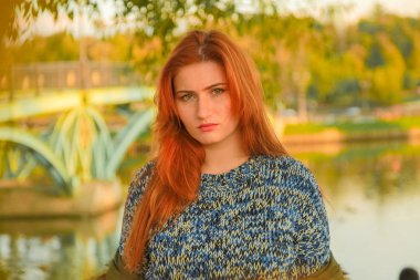 genç güzel artı kırmızı saçlı beyaz kadın sonbahar parkta yürüyor