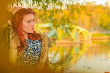 genç güzel artı kırmızı saçlı beyaz kadın sonbahar parkta yürüyor