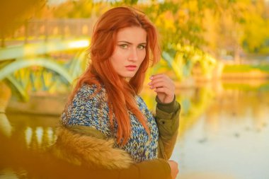 genç güzel artı kırmızı saçlı beyaz kadın sonbahar parkta yürüyor