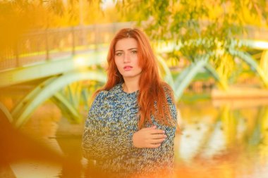 genç güzel artı kırmızı saçlı beyaz kadın sonbahar parkta yürüyor