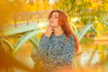 genç güzel artı kırmızı saçlı beyaz kadın sonbahar parkta yürüyor