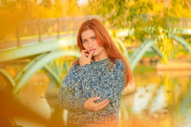 genç güzel artı kırmızı saçlı beyaz kadın sonbahar parkta yürüyor