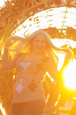 genç güzel artı boyutu beyaz kadın gün batımında sonbahar parkı yürüyor