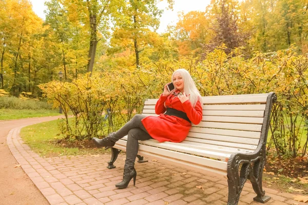 sonbahar parkta akıllı telefon ile genç güzel artı boyutu kafkas kadın