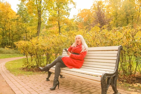 sonbahar parkta akıllı telefon ile genç güzel artı boyutu kafkas kadın